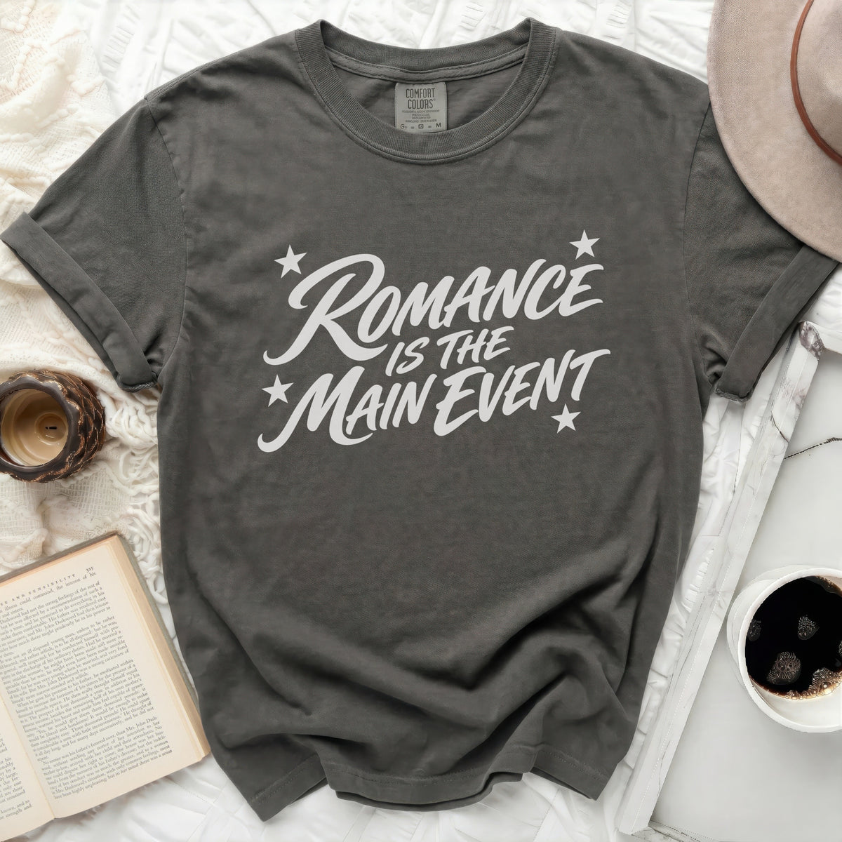 Comfort Colors charcoal t-shirt with white "Romance Is The Main Event" graphic.