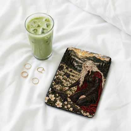 Book with fantasy art of a blonde woman in a field of flowers next to a drink.
