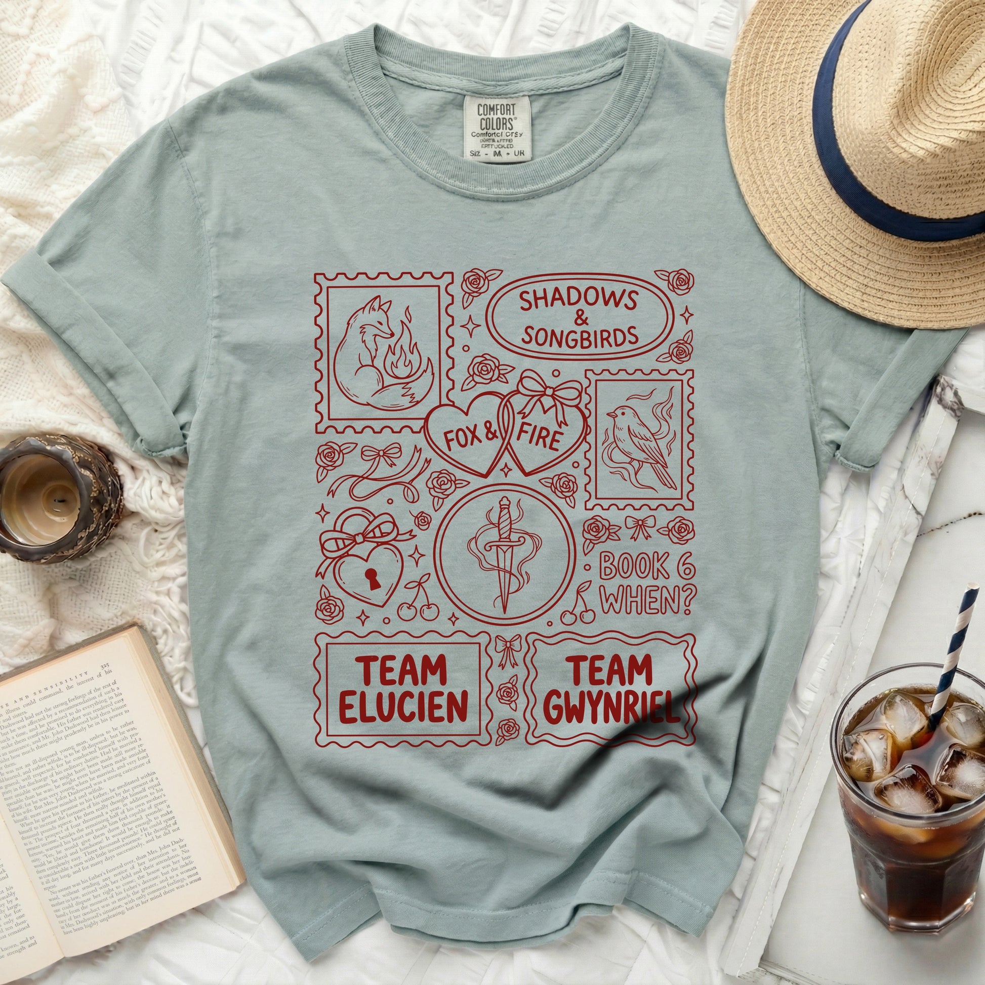 Light blue t-shirt with red "Shadows & Songbirds" graphic and text.