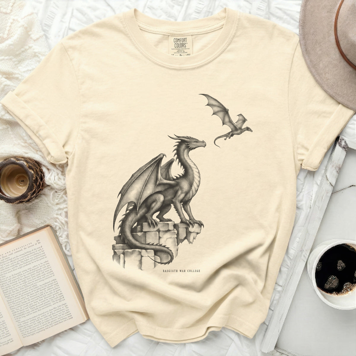 Cream t-shirt with a drawing of two dragons and "BASGIATH WAR COLLEGE" text.