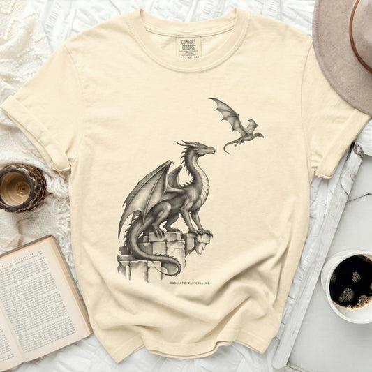 Cream t-shirt with a drawing of two dragons and "BASGIATH WAR COLLEGE" text.