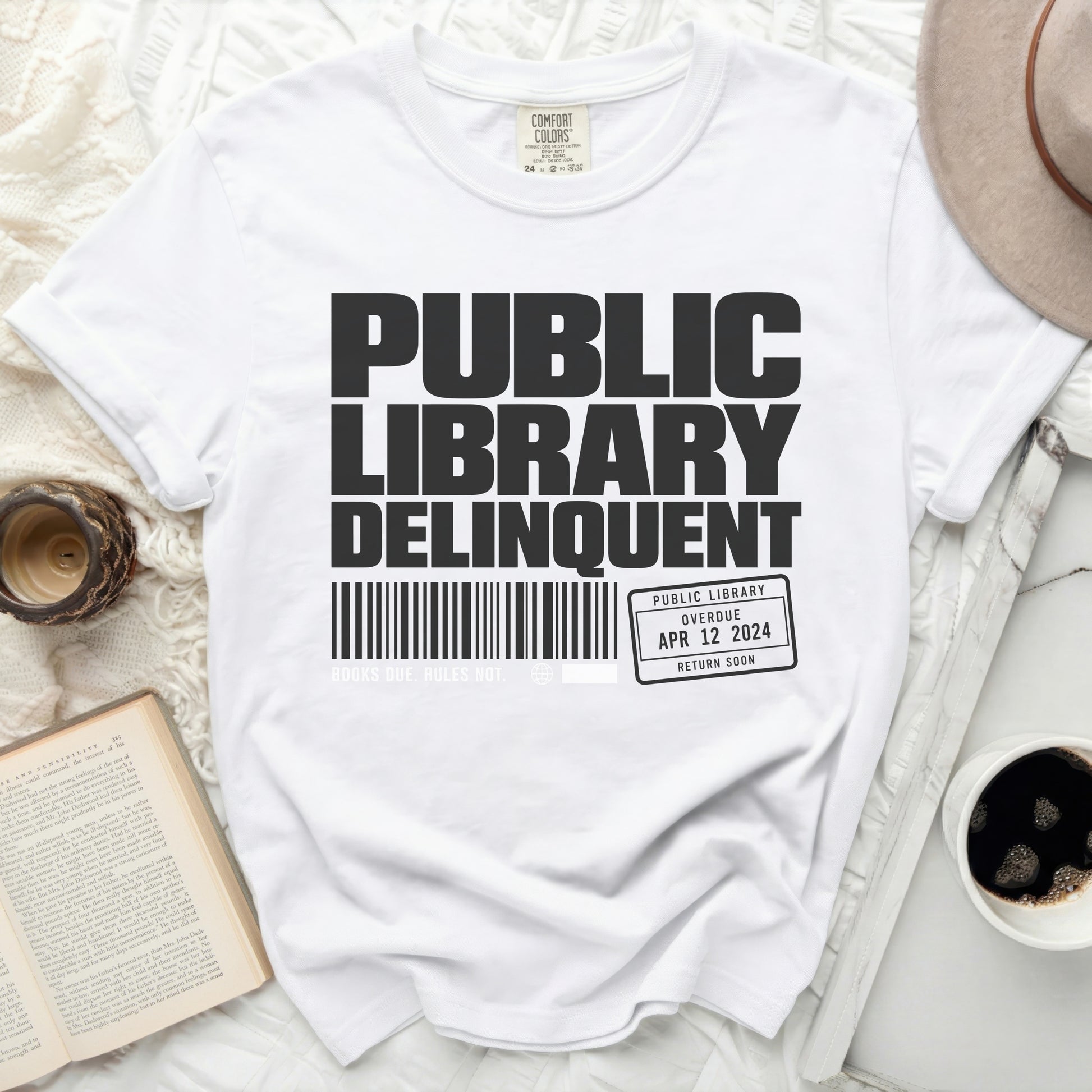 White t-shirt with "Public Library Delinquent" text and library card graphic.