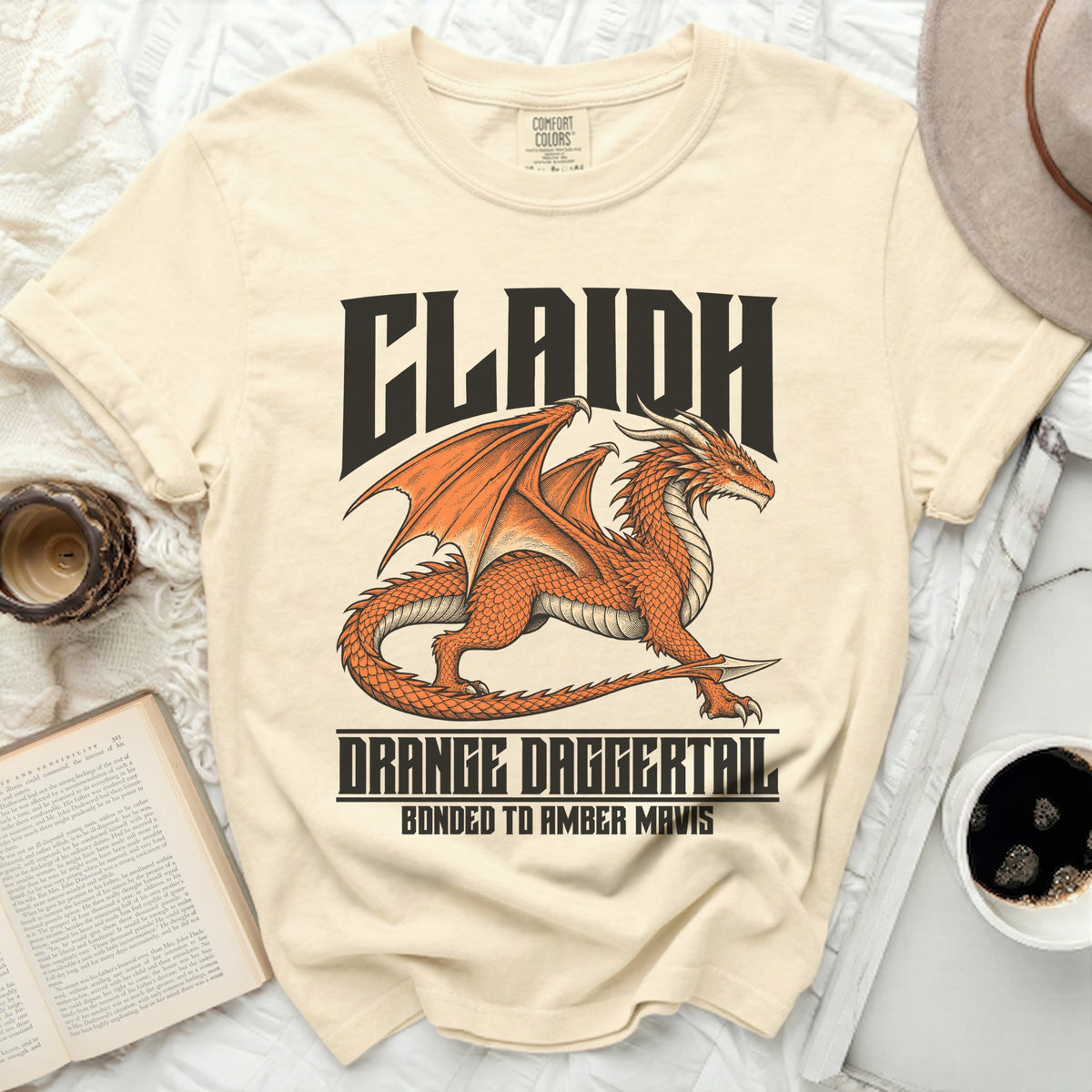 Cream t-shirt with an orange dragon design and text CLAIDH DRANGE DAGGERTAIL BONDED TO AMBER MAVIS.
