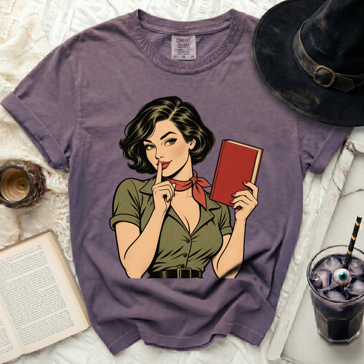 Purple t-shirt with a retro comic illustration of a woman holding a book.