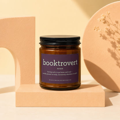 Brown glass candle with "booktrovert" label, definition, and "MAGICMERCHEMPORIUM".