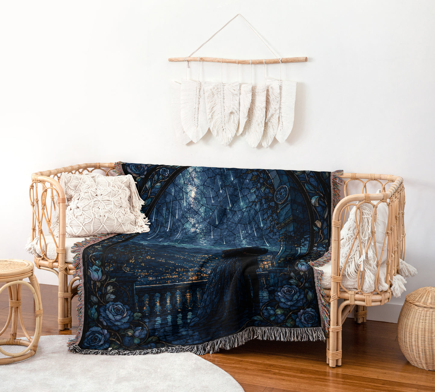a cozy living room with a wicker bench and a blue and black patterned blanket draped over it. The blanket has a floral design and appears to be a throw blanket. Above the bench, there is a wall hanging with white feathers. The room also includes a small table and a woven basket, creating a comfortable and inviting atmosphere.
