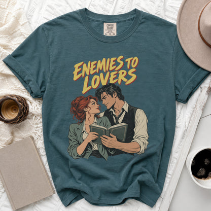 T-shirt with "Enemies to Lovers" text and couple reading a book illustration.