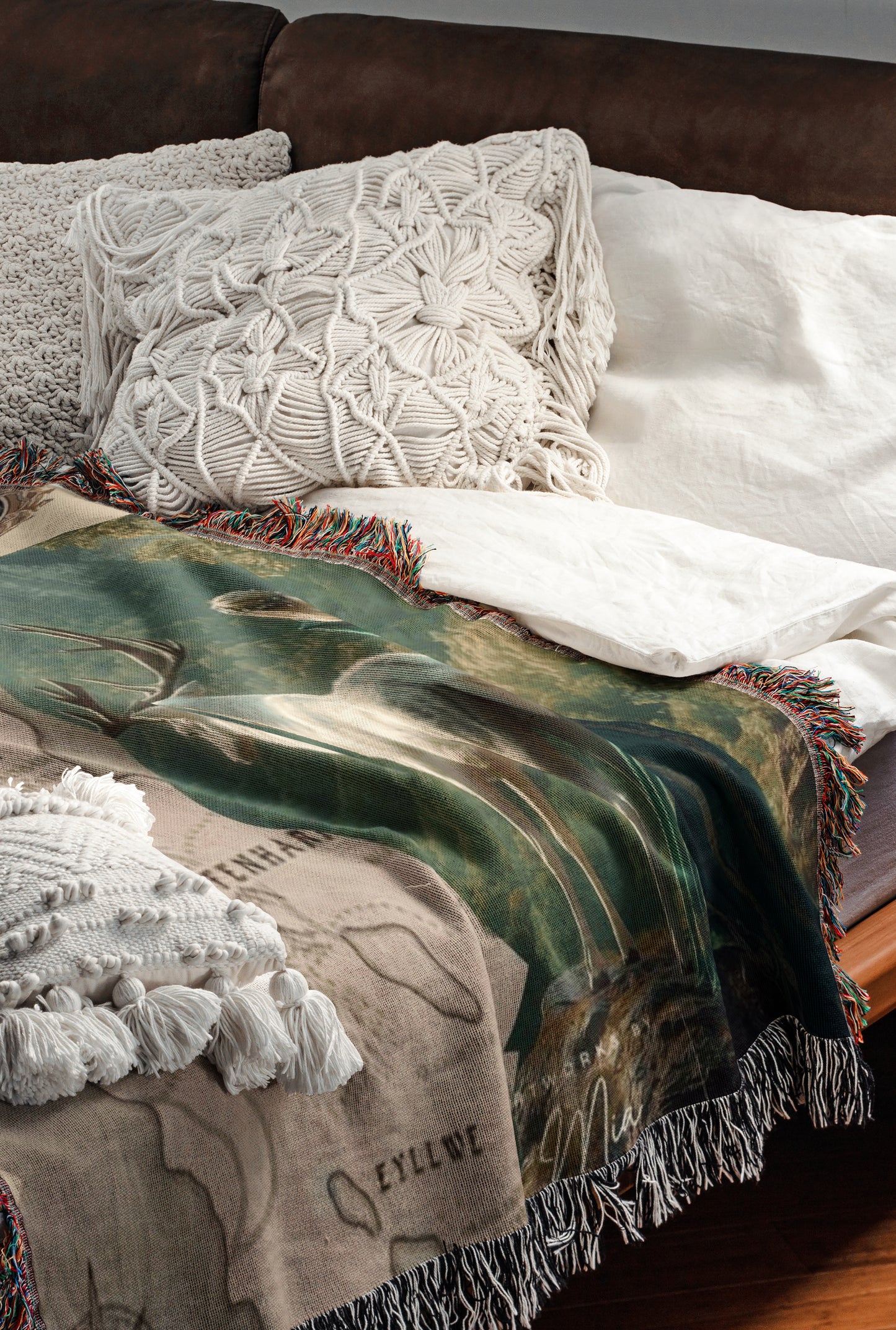 a cozy and inviting bedroom scene, featuring a comfortable bed with a green and brown blanket and a white pillow. The bed is set against a brown leather couch, creating a warm and relaxing atmosphere.