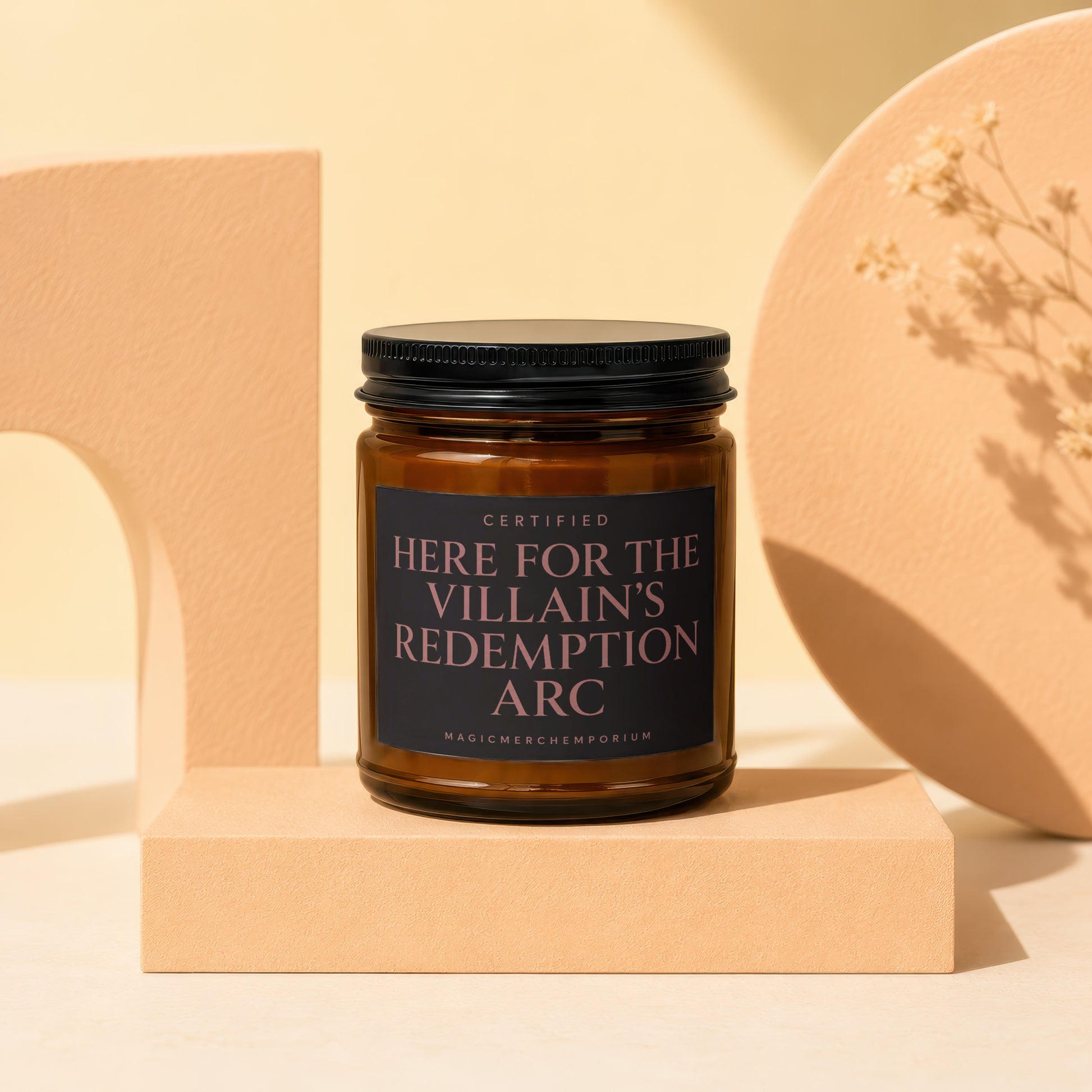 Amber candle with black lid and label reading "Certified Here For The Villain's Redemption Arc".