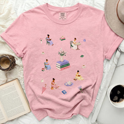 Pink graphic tee with illustrations of women reading and drinking tea.