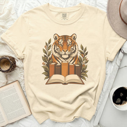 Cream t-shirt with a tiger illustration surrounded by books and foliage.
