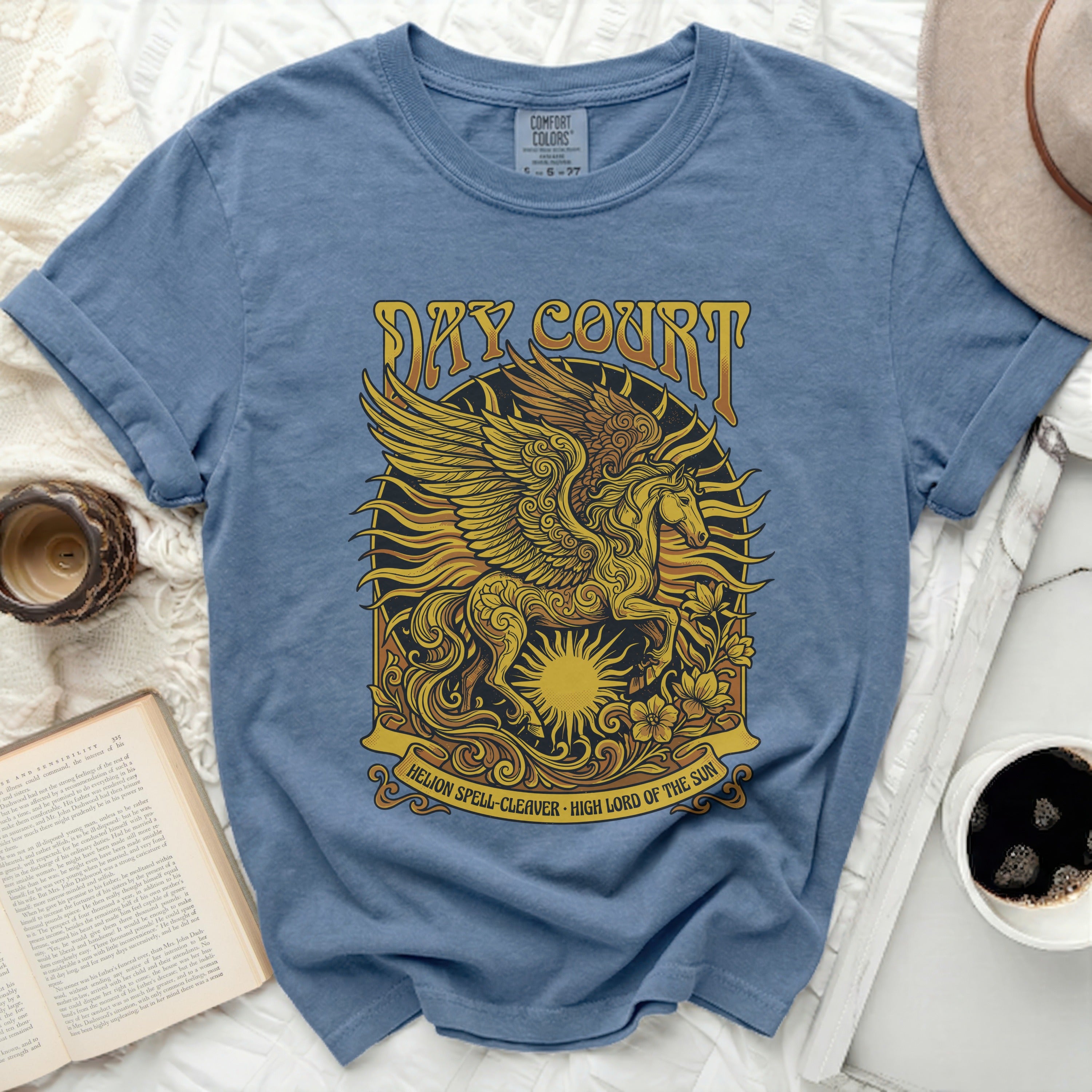 Blue t-shirt with a golden Pegasus and sun graphic, text 