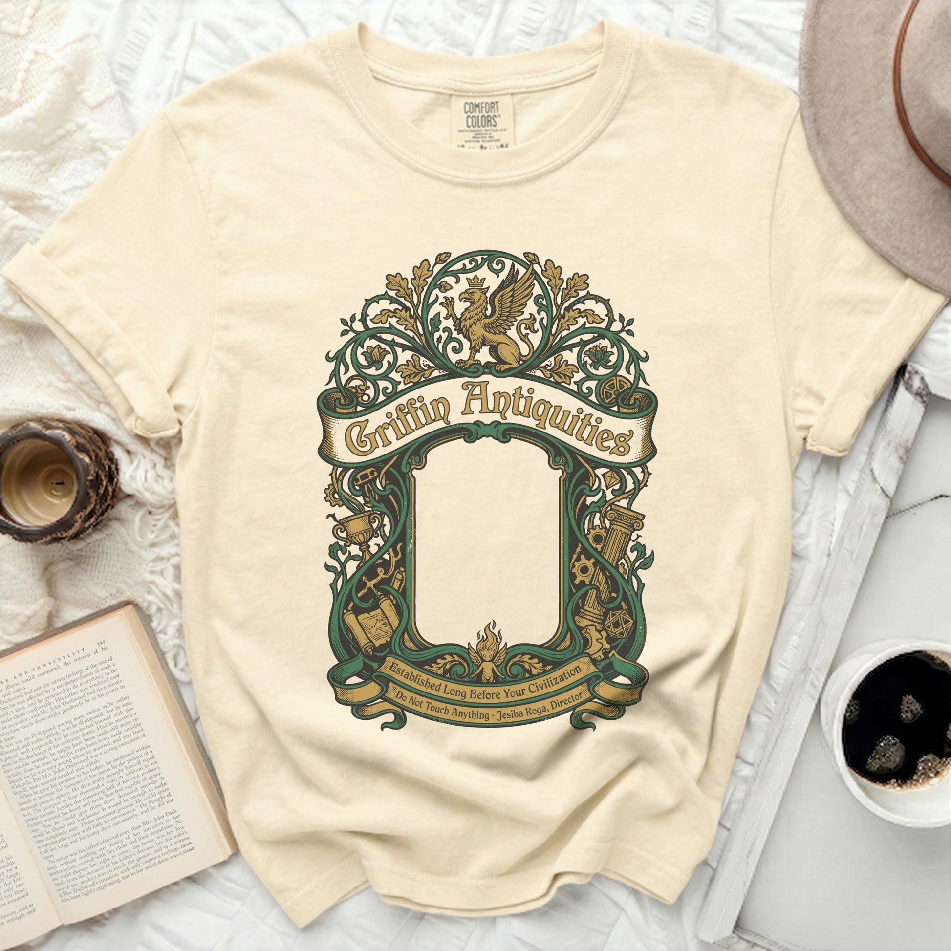 Cream t-shirt with ornate green Griffin Antiquities logo and text.