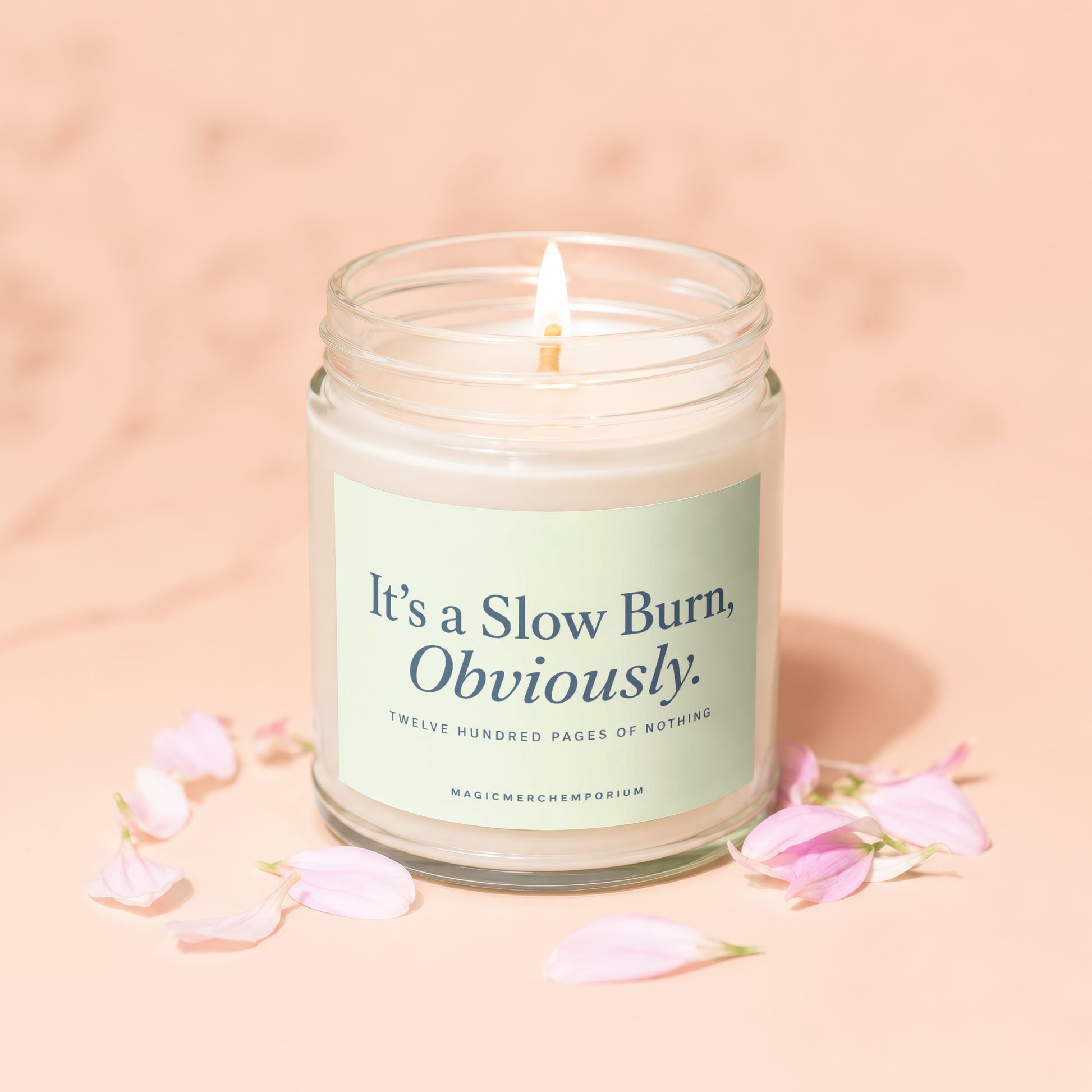 Glass jar candle with lit wick, text "It's a Slow Burn, Obviously."