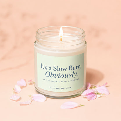 Glass jar candle with lit wick, text "It's a Slow Burn, Obviously."