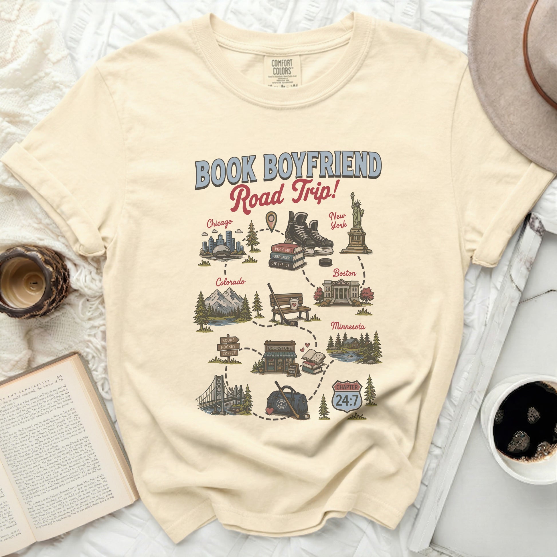 Cream t-shirt with "Book Boyfriend Road Trip" map graphic and city illustrations.