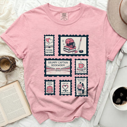 Pink t-shirt with postage stamps featuring hockey and book themes.