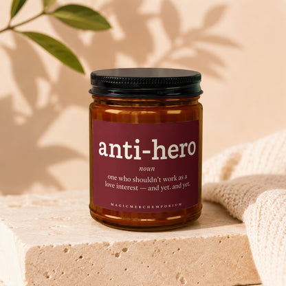Amber jar candle with "anti-hero noun one who shouldn't work as a love interest — and yet. and yet." text.