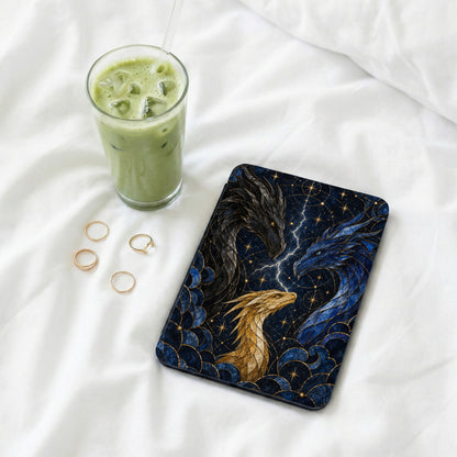 Case with three dragons, lightning, and stars, next to iced matcha drink and rings.