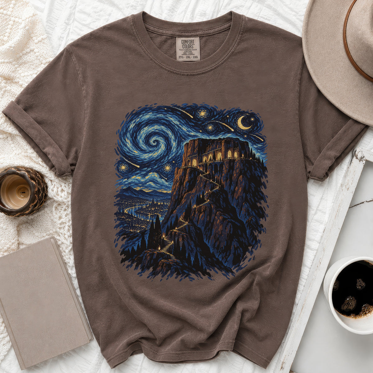 Brown t-shirt featuring a castle on a cliff under a swirling starry night sky.