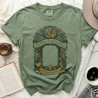 Green t-shirt with "Griffin Antiquities" and ornate border design.