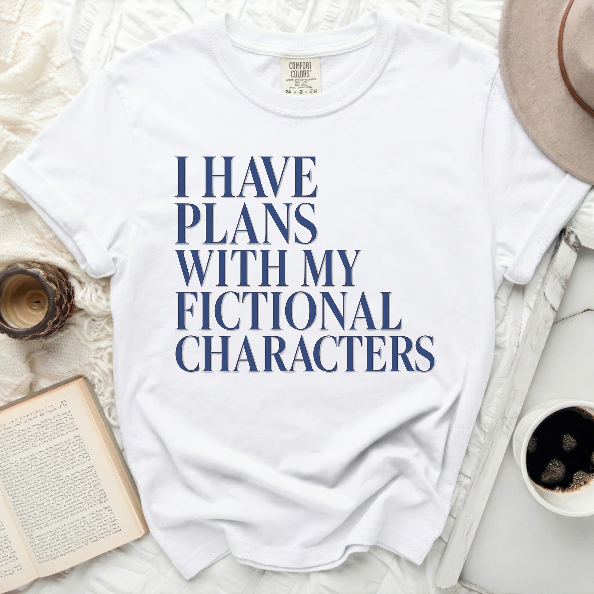 White t-shirt with "I HAVE PLANS WITH MY FICTIONAL CHARACTERS" printed in navy blue.