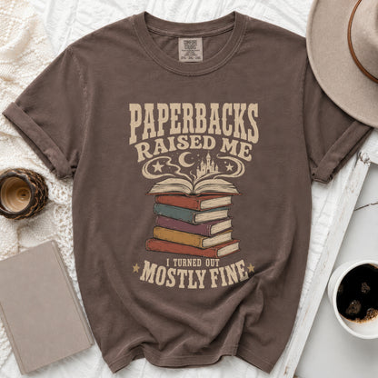 Brown t-shirt with "Paperbacks Raised Me, I Turned Out Mostly Fine" text and book graphic.