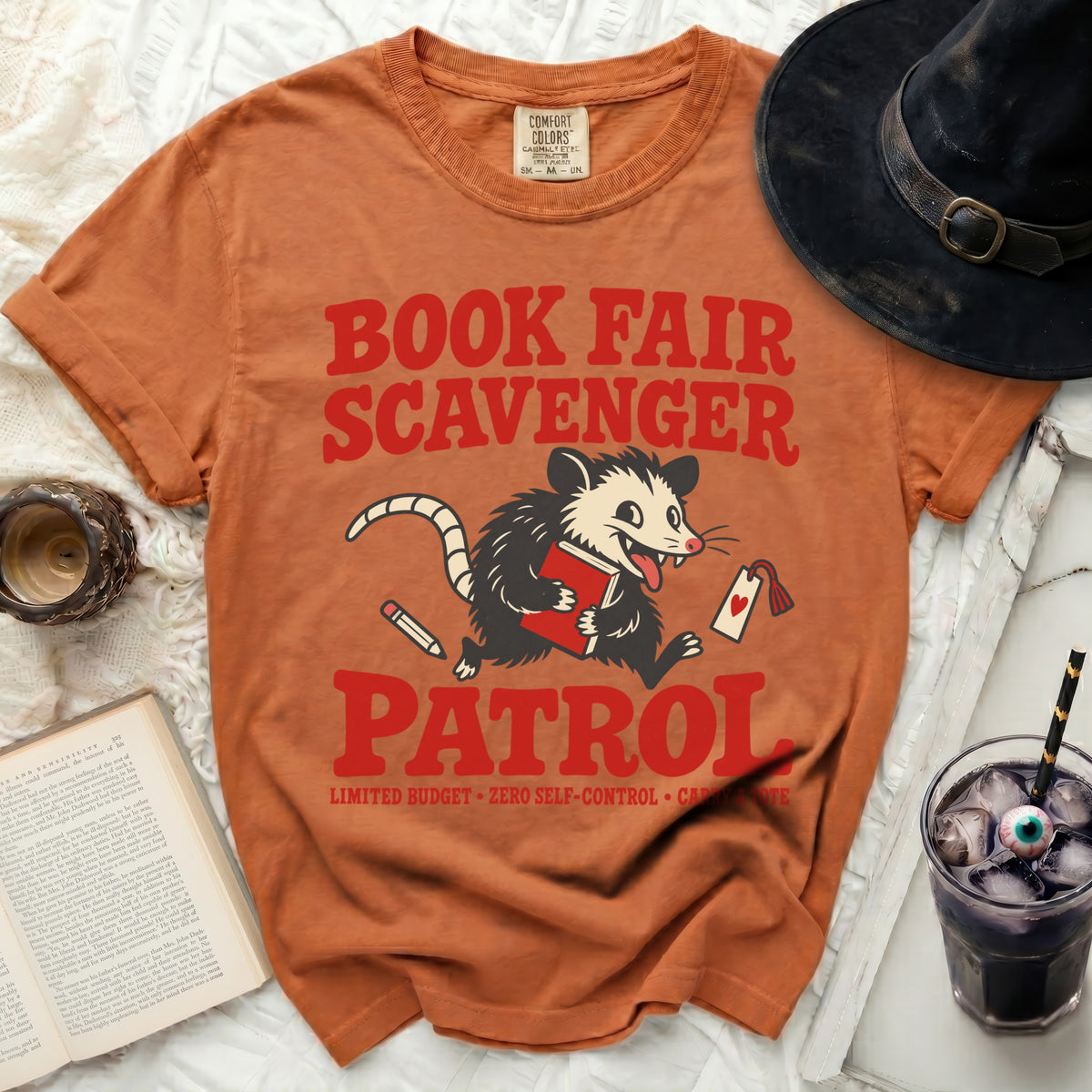 Orange t-shirt with "Book Fair Scavenger Patrol" and a cartoon possum.