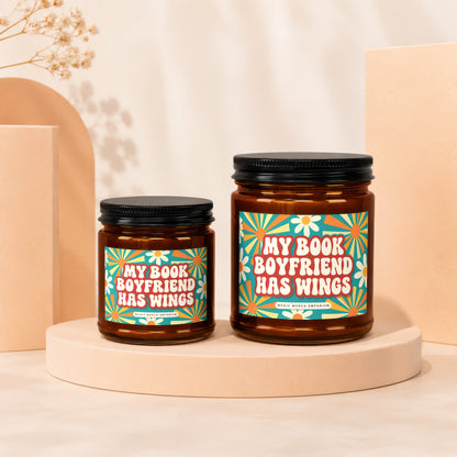 Two amber glass candles with black lids, labeled "My Book Boyfriend Has Wings".