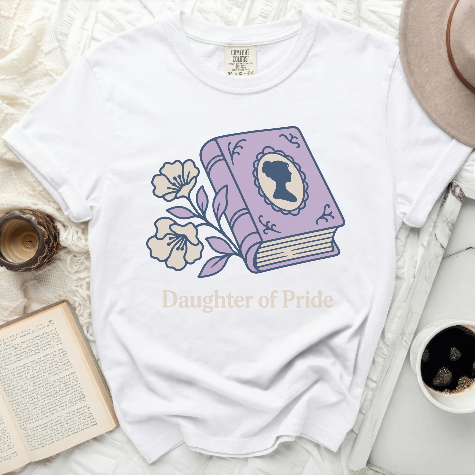 White t-shirt with purple book illustration and "Daughter of Pride" text.