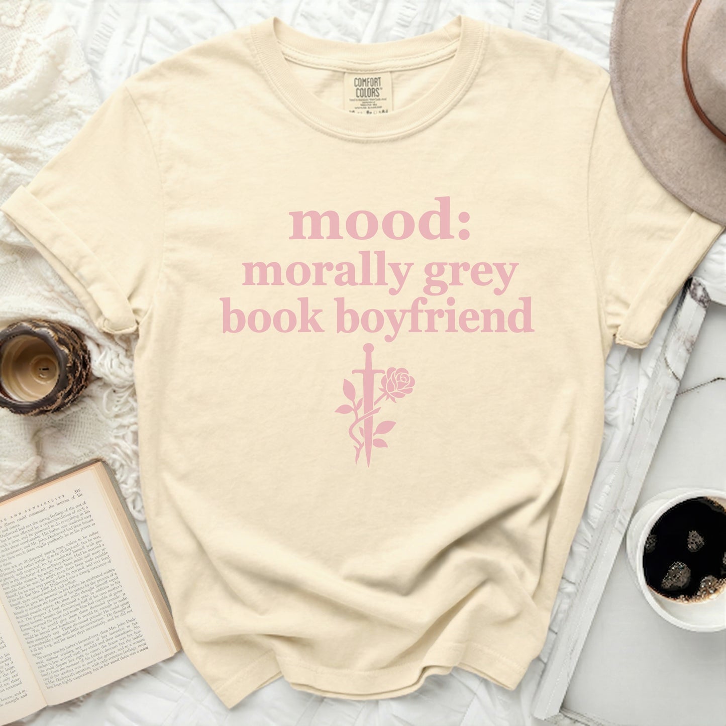 Cream Comfort Colors t-shirt with pink text "mood: morally grey book boyfriend" and sword rose graphic.