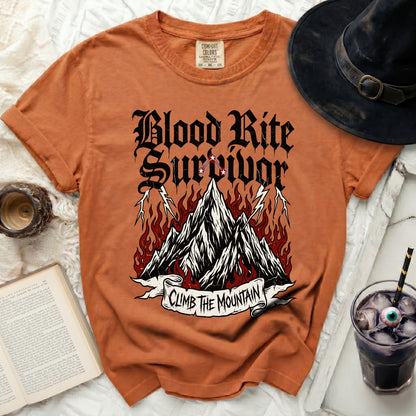 Orange t-shirt with "Blood Rite Survivor Climb The Mountain" graphic and witchcraft elements.
