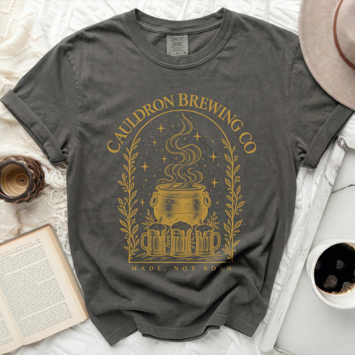 Charcoal gray t-shirt with a gold graphic of a cauldron, beer mugs, stars, and text.