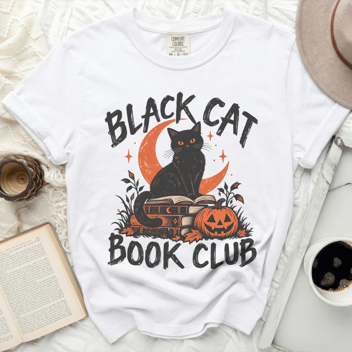 White t-shirt with black cat on books, pumpkin, and text "BLACK CAT BOOK CLUB".