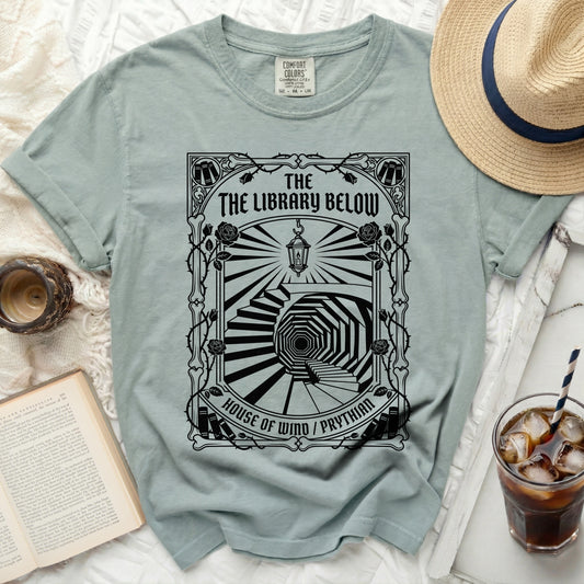 T-shirt with "The Library Below" and a spiraling staircase design.