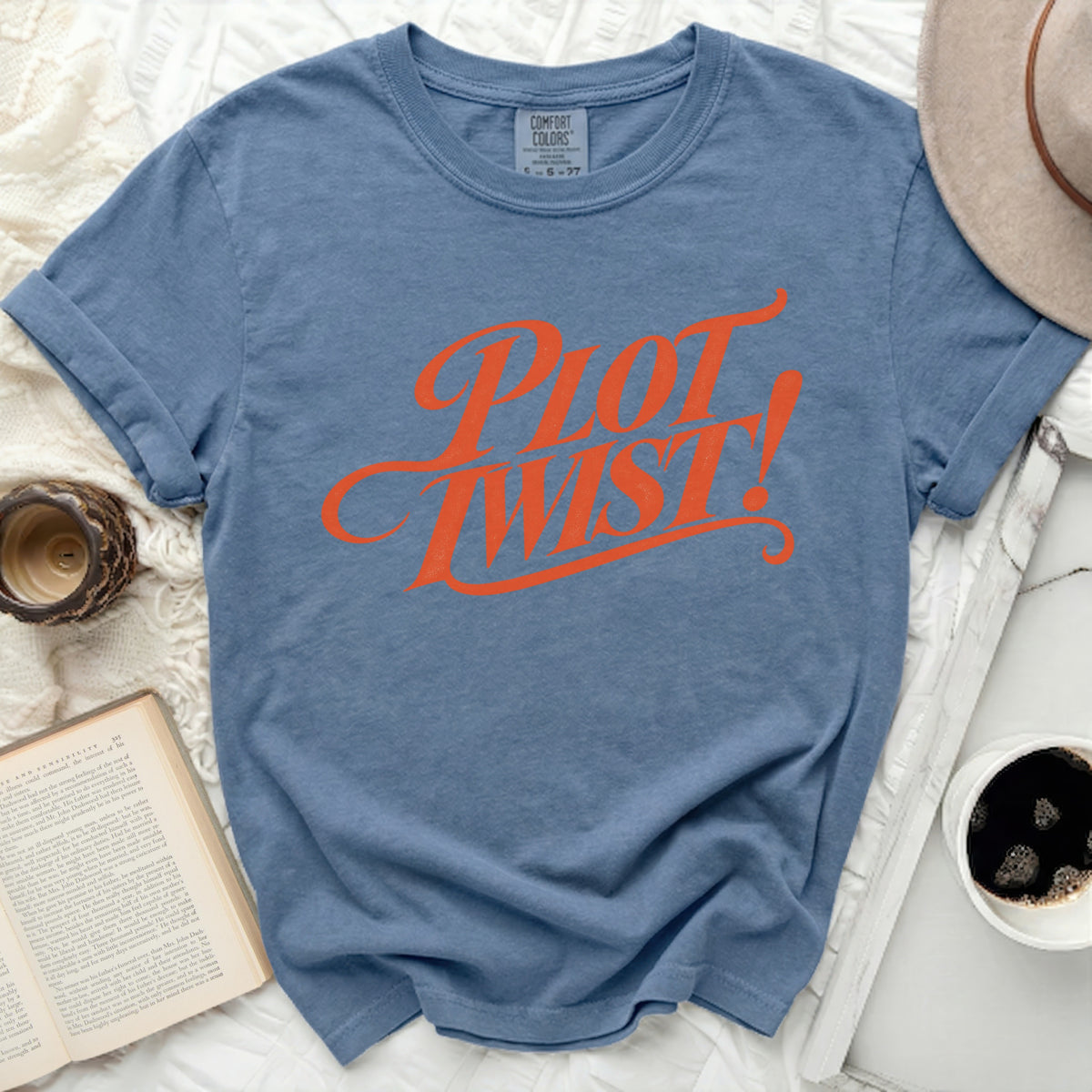 Blue t-shirt with "Plot Twist!" in orange cursive text.