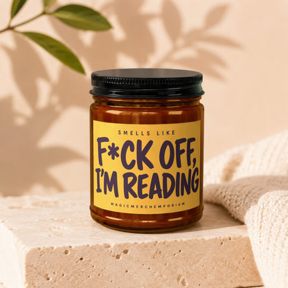 Amber jar candle with yellow label reading "Smells like F*ck Off, I'm Reading".