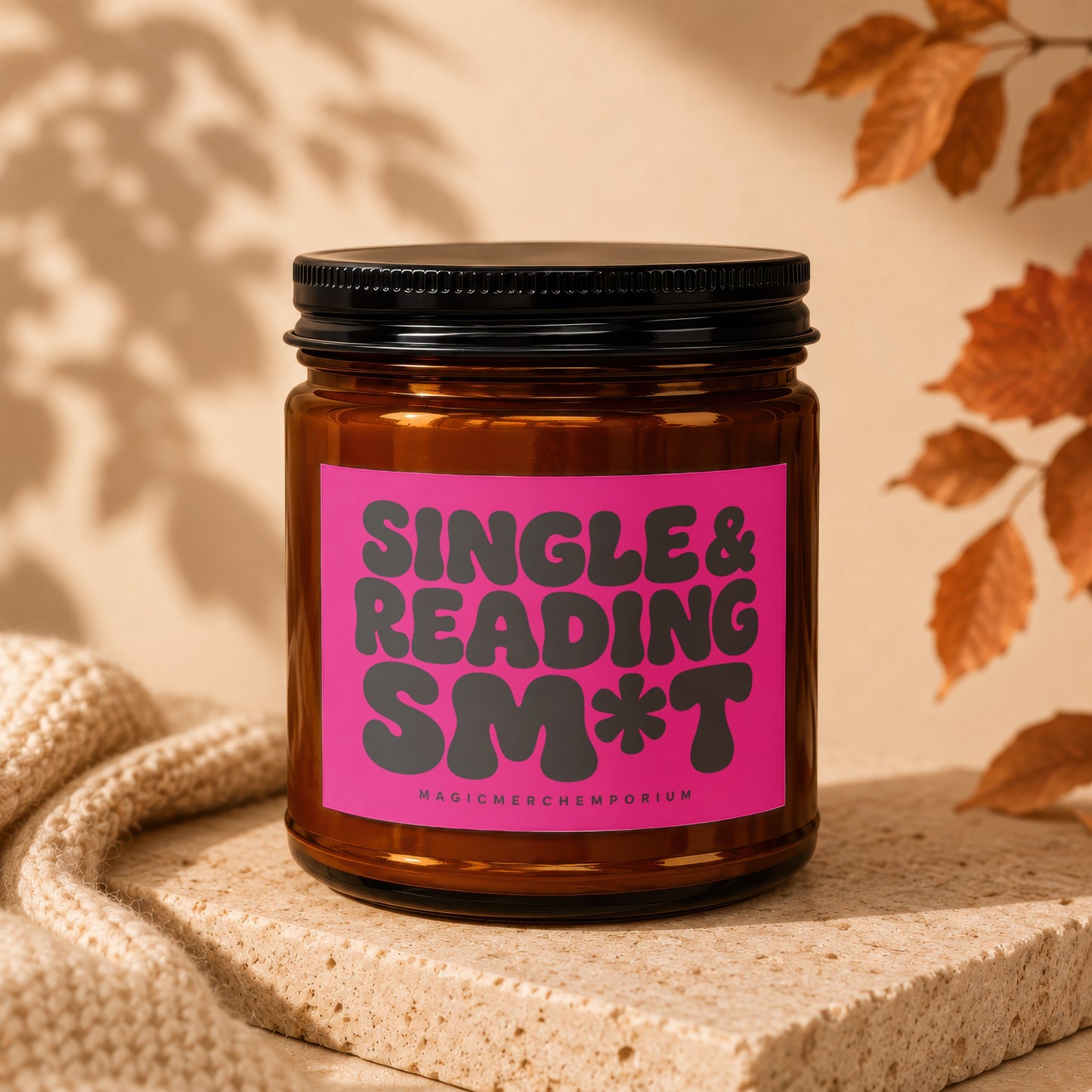 Amber jar candle with pink label reading "SINGLE & READING SM*T MAGICMER⸝⸝EMPORIUM".