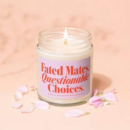Glass candle with lit wick and pink label reading "Fated Mates. Questionable Choices."