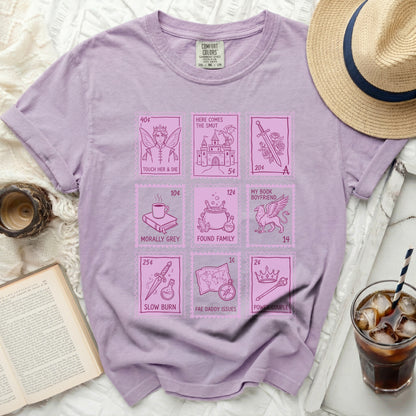 Purple t-shirt with "Here Comes the Smut" and literary tropes in postage stamp designs.