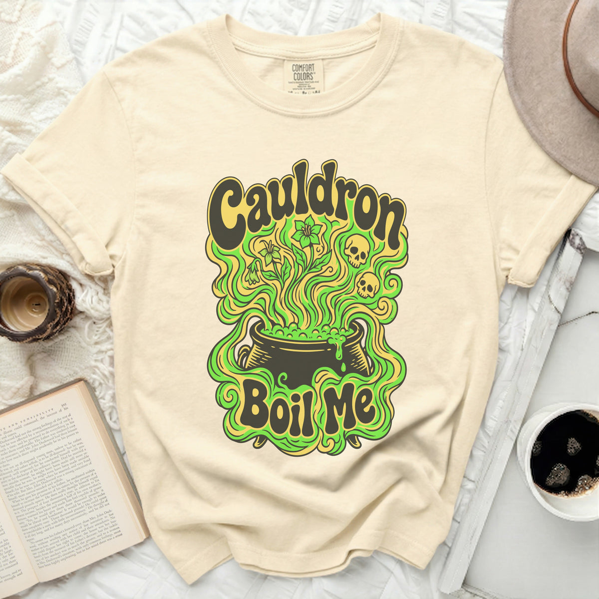 Cream Comfort Colors t-shirt with retro "Cauldron Boil Me" graphic featuring skulls and flowers.