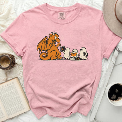 Pink t-shirt with cartoon of dragon reading to ghosts.
