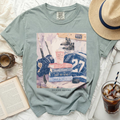 T-shirt with hockey gear, books, and "Pucking Around" text.