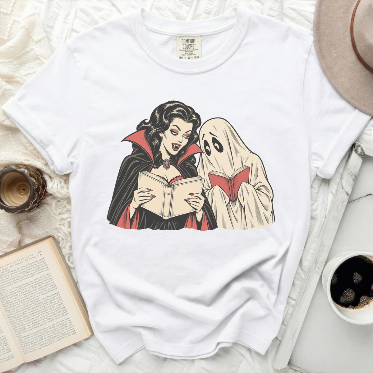 Vampire and ghost reading books graphic on a white Comfort Colors t-shirt.