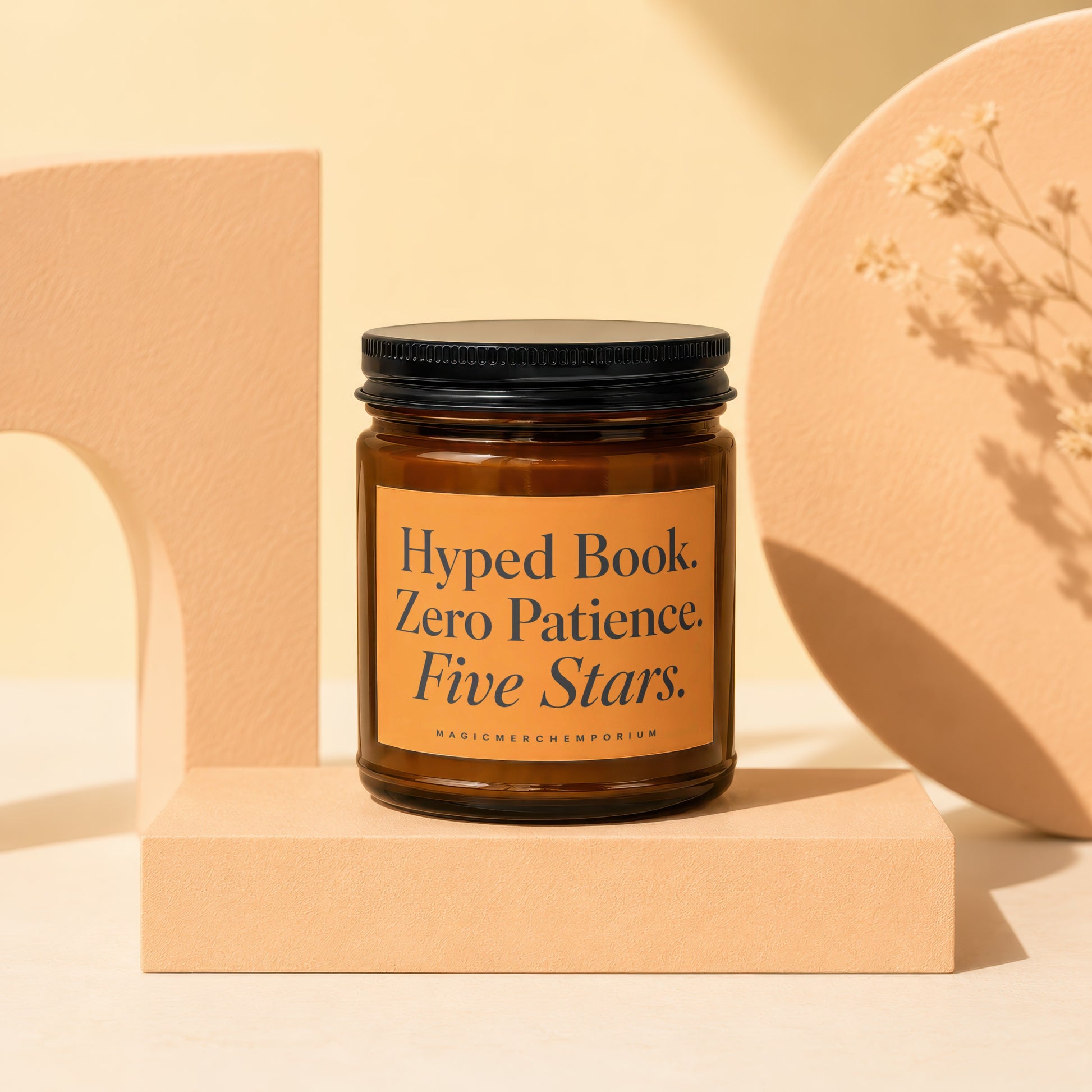 Amber glass candle with black lid, label reads "Hyped Book. Zero Patience. Five Stars."