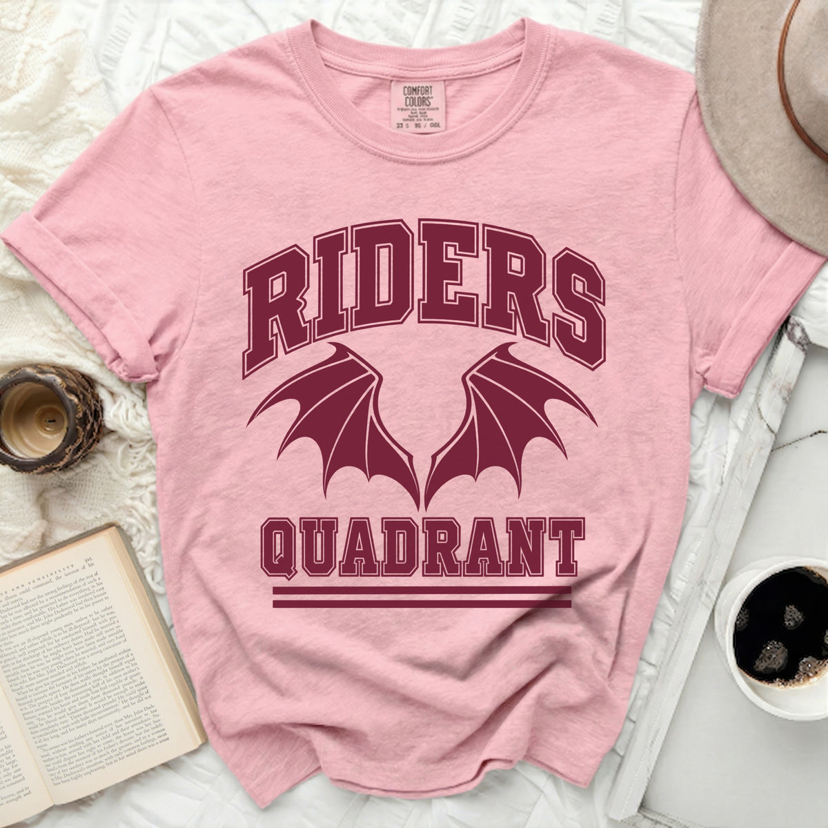 Pink t-shirt with "RIDERS QUADRANT" and bat wings graphic.