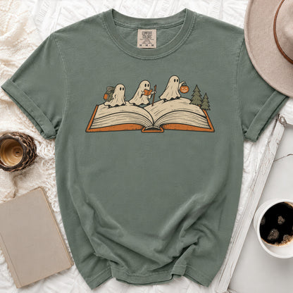 T-shirt with three ghosts on an open book, one carrying a backpack.
