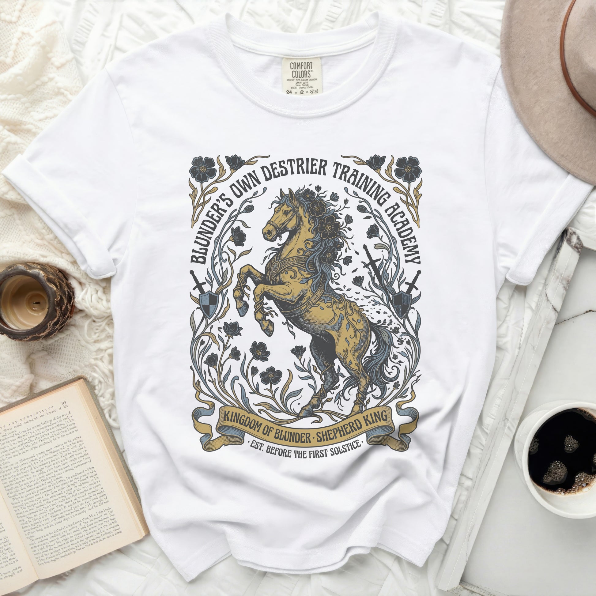 White t-shirt with "Blunder's Own Destrier Training Academy" graphic.