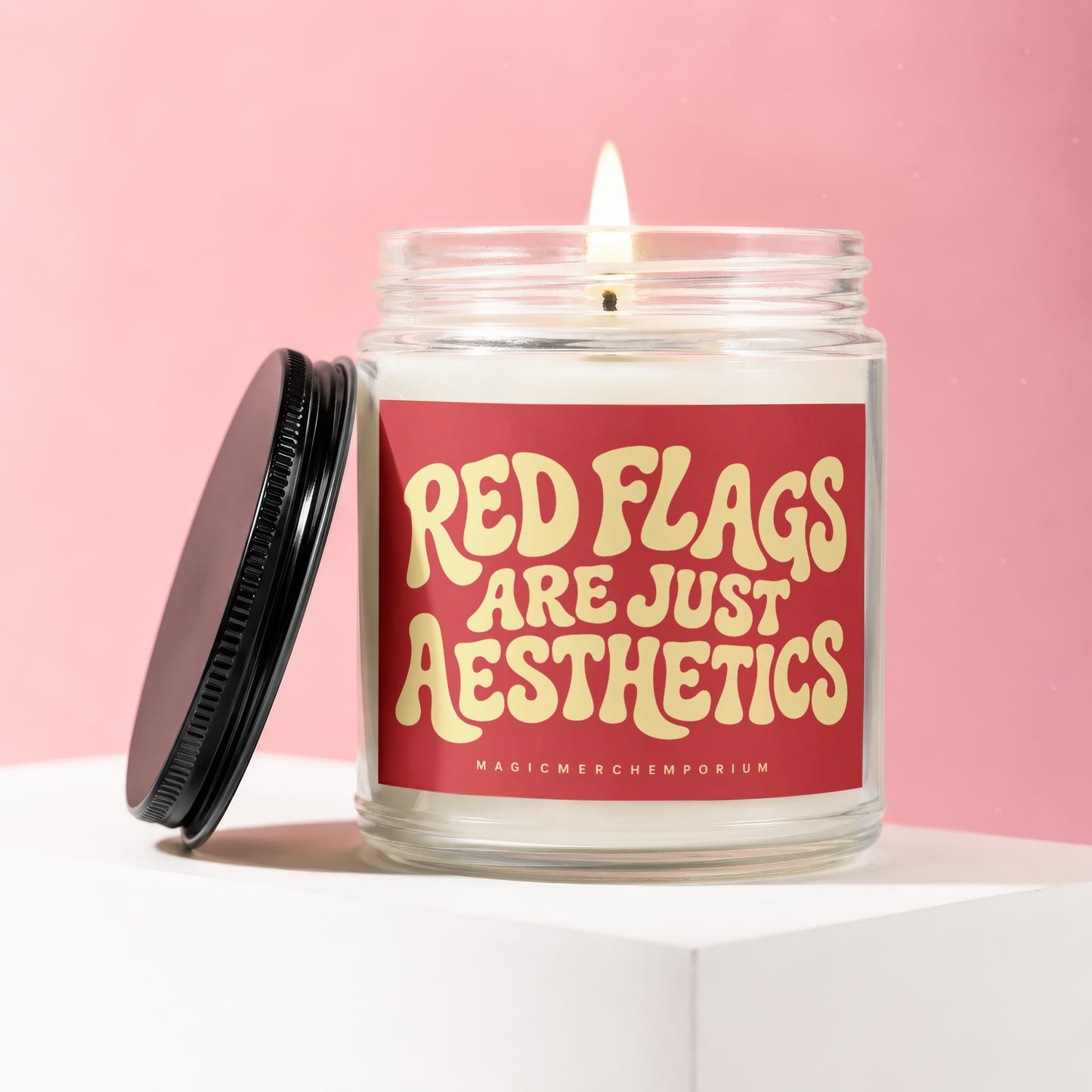 Candle with red label reading "Red Flags Are Just Aesthetics".