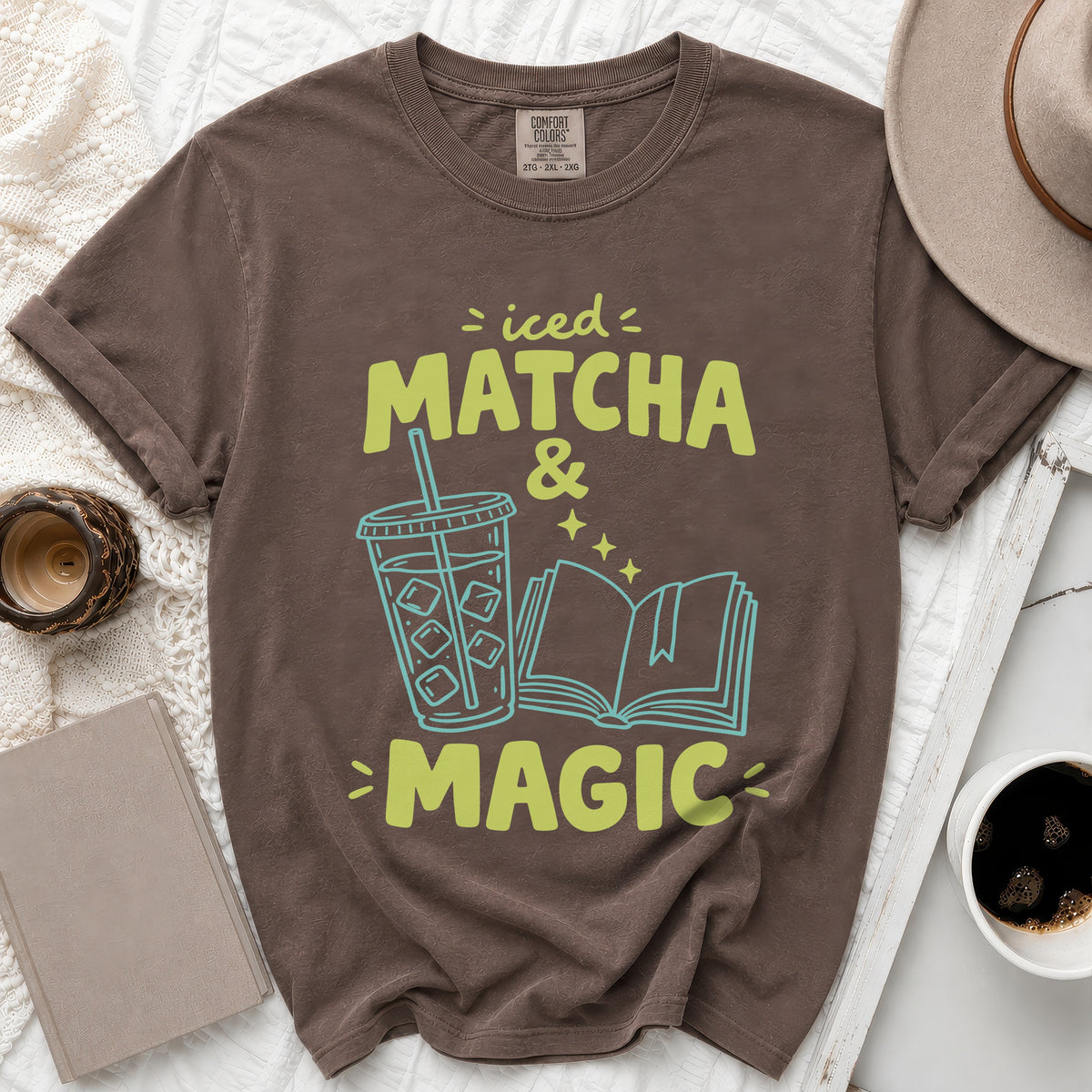 Brown t-shirt with "iced MATCHA & MAGIC" text, iced drink, and open book graphic.